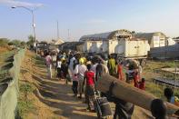 Civilians arrive for shelter at the United Nations Mission in the Republic of South Sudan (UNMISS) compound in Bor, South Sudan in this December 18, 2013 picture provided by the UNMISS. South Sudan's army said it had lost control of the flashpoint town of Bor on Wednesday, its first acknowledged reversal in three days of clashes between rival groups of soldiers that have triggered warnings of a slide into civil war. Picture taken on December 18. REUTERS/UNMISS/Handout via Reuters (SOUTH SUDAN - Tags: CIVIL UNREST POLITICS) ATTENTION EDITORS - THIS IMAGE WAS PROVIDED BY A THIRD PARTY. FOR EDITORIAL USE ONLY. NOT FOR SALE FOR MARKETING OR ADVERTISING CAMPAIGNS. THIS PICTURE IS DISTRIBUTED EXACTLY AS RECEIVED BY REUTERS, AS A SERVICE TO CLIENTS. NO SALES. NO ARCHIVES