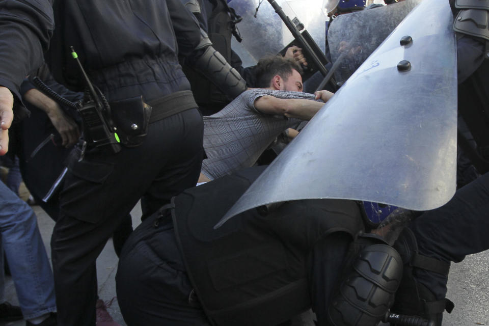 Security forces arrest a man as Algerian demonstrators take to the streets in the capital Algiers to protest against the government and reject the upcoming presidential elections, in Algeria, Wednesday, Dec. 11, 2019. Algeria's powerful army chief promises that a presidential election on Thursday will define the contours of a new era for a nation where the highest office has stood vacant for eight months. The tenacious pro-democracy movement which forced leader Abdelaziz Bouteflika to resign after 20 years in power doesn't trust the confident claim and is boycotting the vote. (AP Photo/Fateh Guidoum)