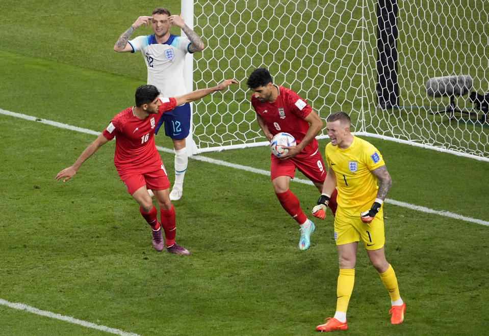 England's goalkeeper Jordan Pickford, right, reacts after a goal was scored by Iran's Mehdi Taremi, second from right, during the World Cup group B soccer match between England and Iran at the Khalifa International Stadium in Doha, Qatar, Monday, Nov. 21, 2022. (AP Photo/Pavel Golovkin)