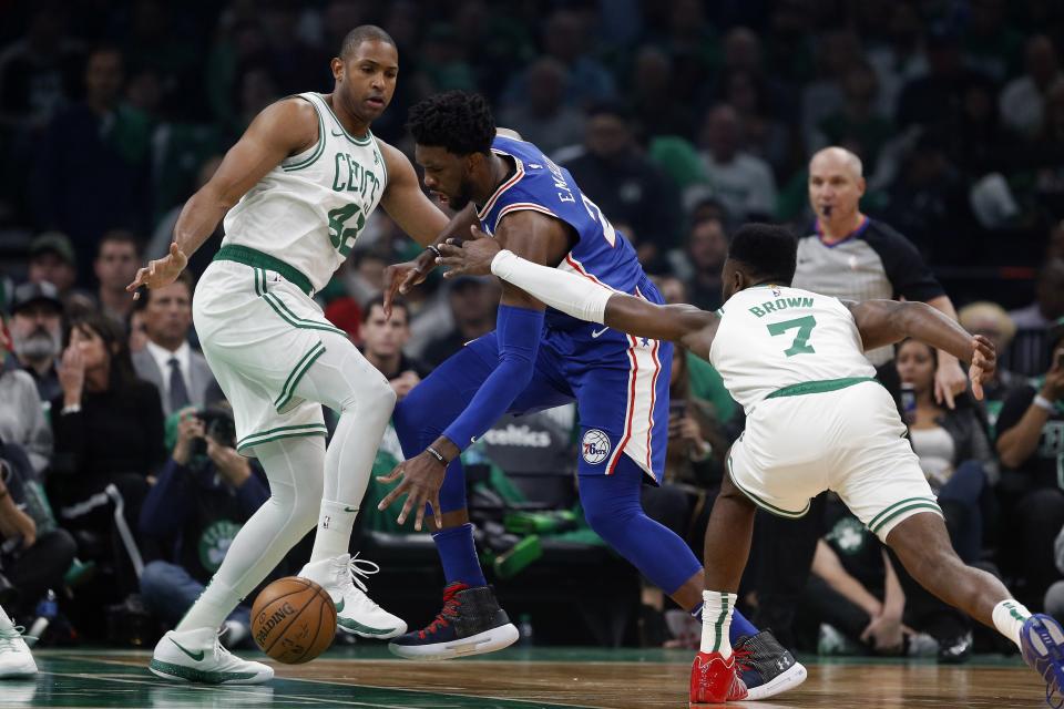 Philadelphia 76ers' Joel Embiid drives between Boston Celtics' Al Horford (42) and Jaylen Brown (7) during the first half of an NBA basketball game in Boston, Tuesday, Oct 16, 2018. (AP Photo/Michael Dwyer)