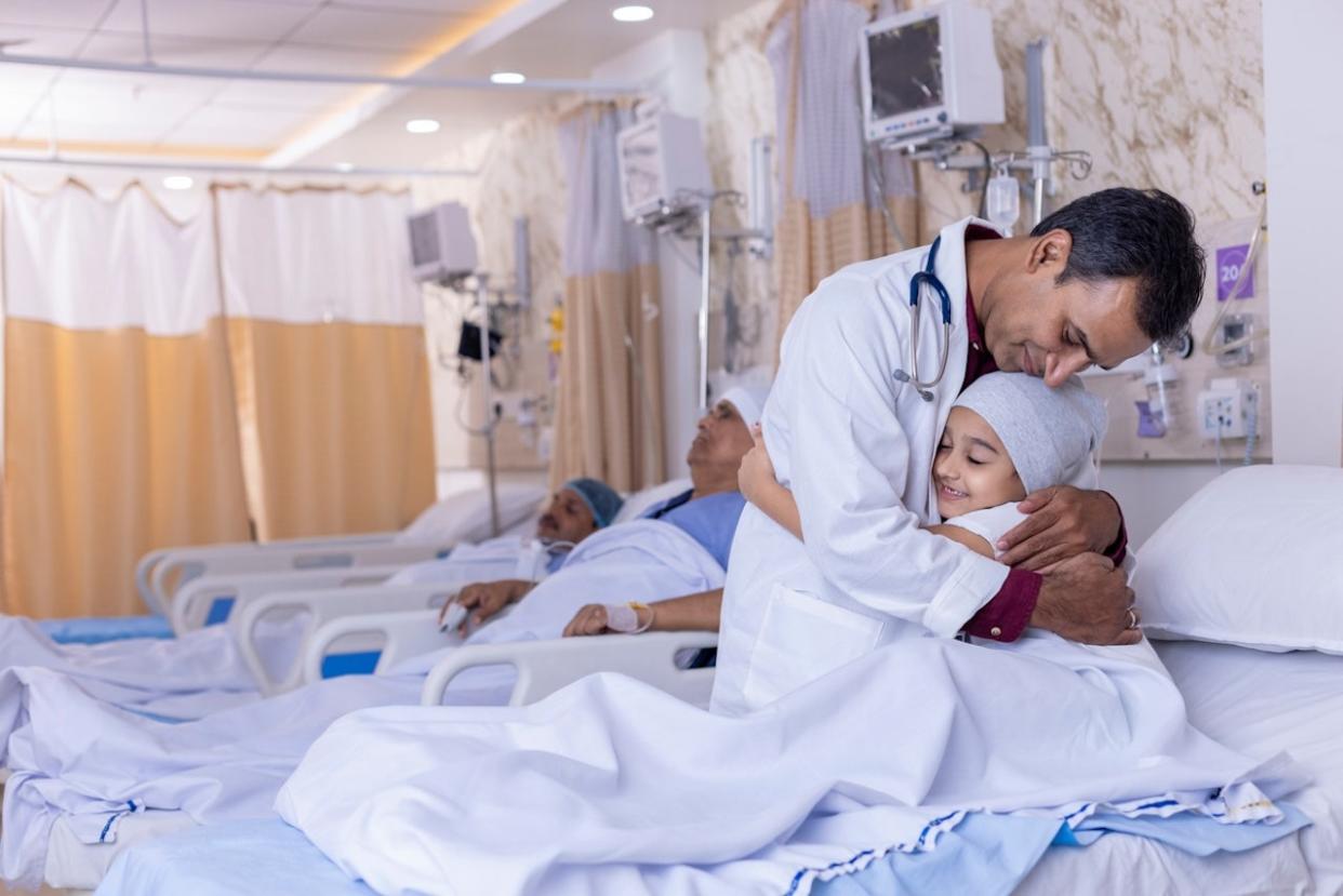 Doctor hugging child