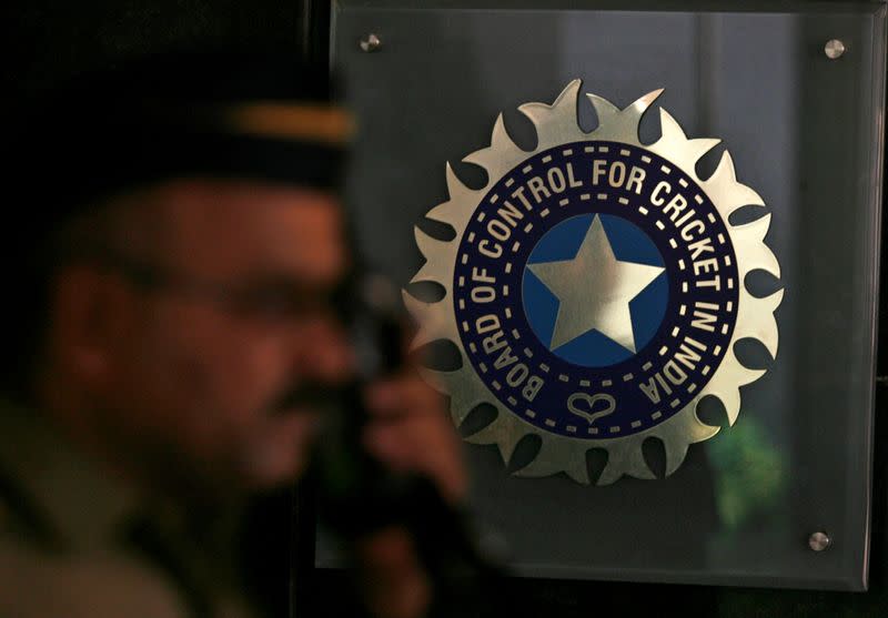 FILE PHOTO: A policeman walks past logo of BCCI in Mumbai