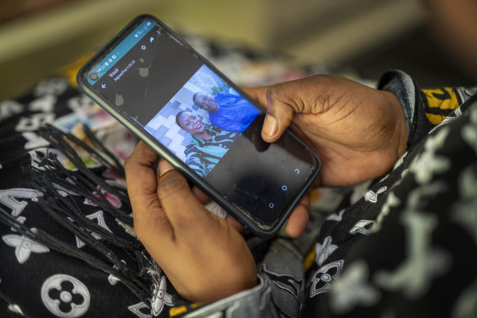 Vanessa Emedy looks at photographs of her late husband Godefroid Kamana in Goma, Democratic Republic of the Congo, Thursday March 31, 2022. The night of his burial, extended family members came to the family home where Vanessa had just begun her period of mourning. "They didn't wait the 40 days," she lamented. "I was stripped of everything, of all my possessions." (AP Photo/Jerome Delay)