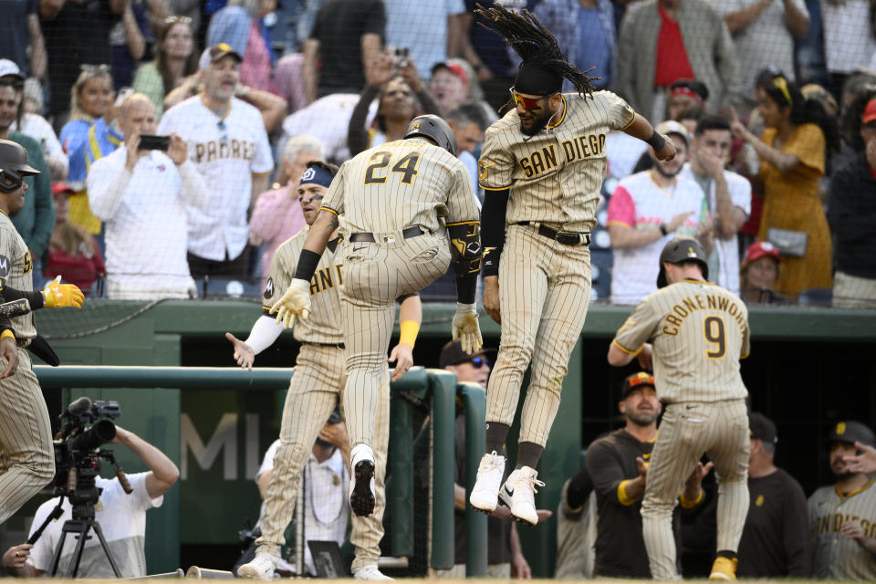 San Diego Padres' Rougned Odor (24) celebrates his three-run home run with Fernando Tatis Jr., center, during the ninth inning of the team's baseball game against the Washington Nationals, Thursday, May 25, 2023, in Washington. The Padres won 8-6. (AP Photo/Nick Wass)