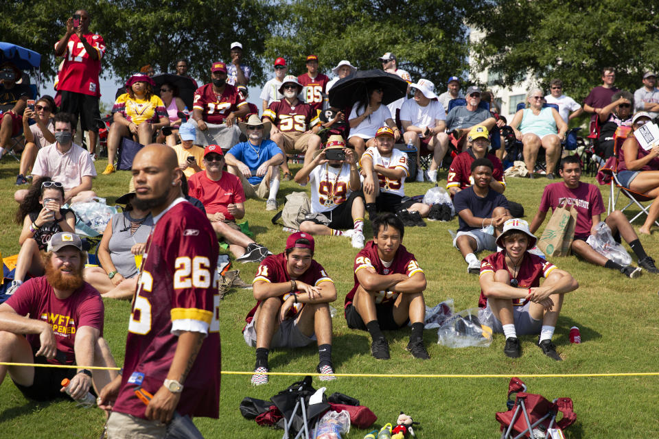 FILE - Washington Football Team fans watch drills during NFL football practice in Richmond, Va., in this Wednesday, July 28, 2021, file photo. It's not exactly everyone into the pool, or gathering around the bonfire. The NFL's “Back Together Saturday” at training camps is all about football. Well, also about having fans return to watch, with all 32 teams conducting open practices on Saturday as part of a unified effort by the league. (AP Photo/Ryan M. Kelly, File)