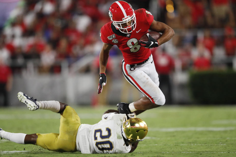 Notre Dame cornerback Shaun Crawford (20) tackles Georgia wide receiver Dominick Blaylock (8) during the first half of an NCAA college football game, Saturday, Sept. 21, 2019, in Athens, Ga. (AP Photo/John Bazemore)