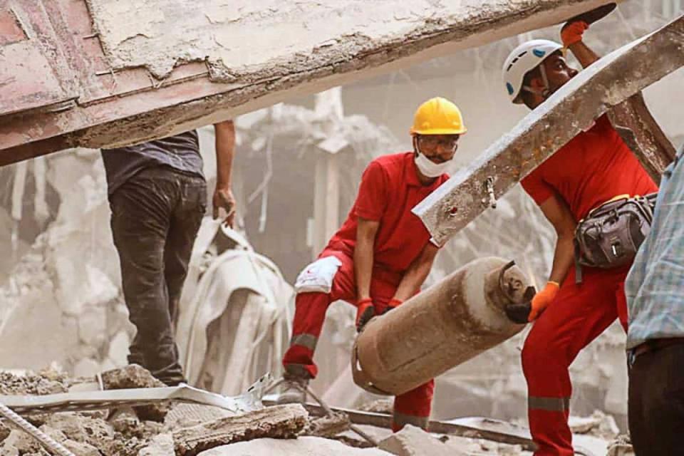 Iranian Red Crescent Society workers help clear the collapsed building (EPA)