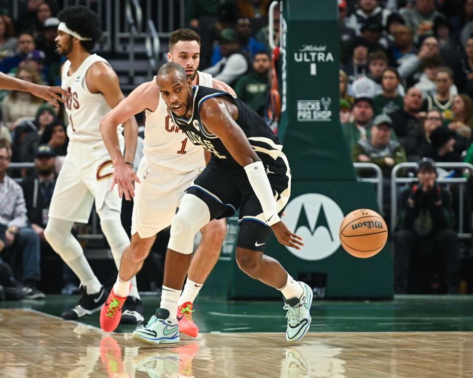 Milwaukee Bucks forward Khris Middleton (22) and Cleveland Cavaliers guard Max Strus (1) chase a loose ball in the first half of their game Friday, January 26, 2024, at Fiserv Forum in Milwaukee, Wisconsin.