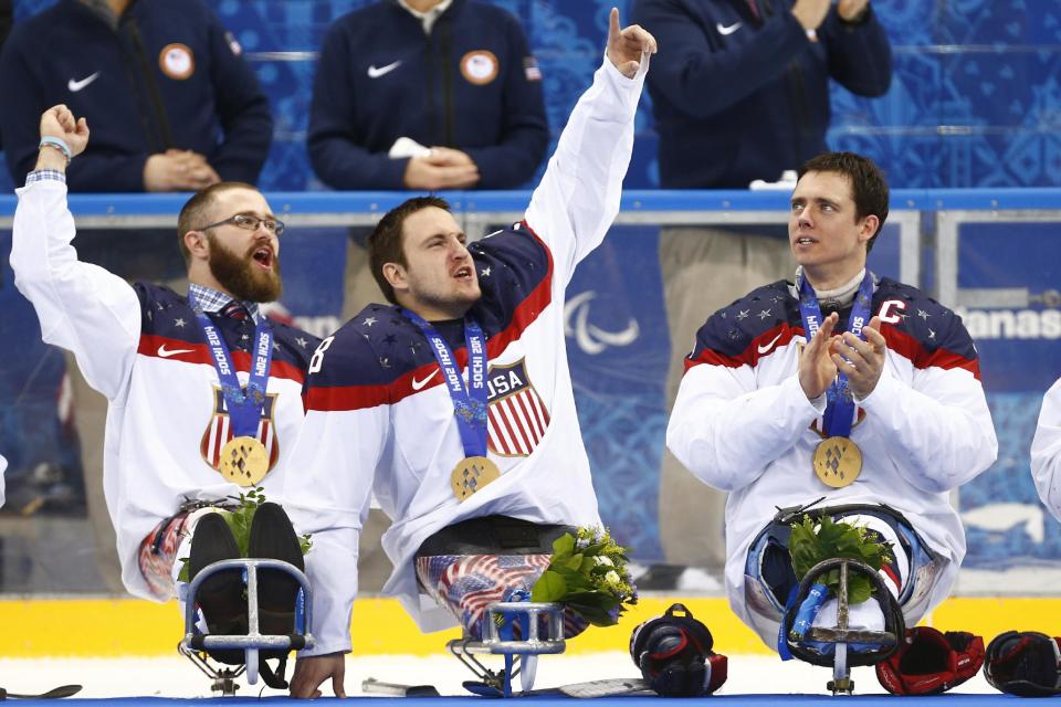 United States players Taylor Lipsett, left, Greg Shaw, center, and Andy Yohe celebrate after winning the gold medal ice sledge hockey match against Russia at the 2014 Winter Paralympics in Sochi, Russia, Saturday, March 15, 2014. United States won 1-0. (AP Photo/Pavel Golovkin)