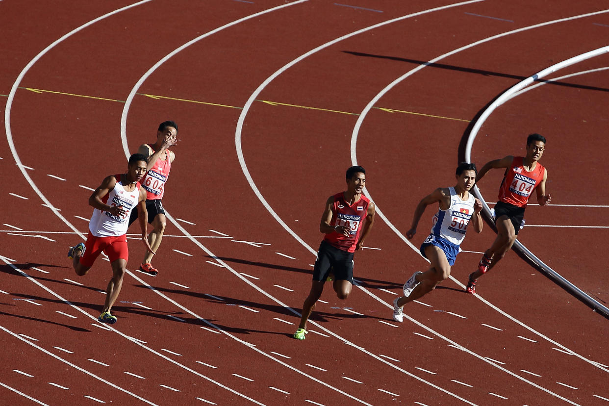 NAY PYI TAW, BURMA - DECEMBER 18: (L-R) Rozikin Muhammad Rozikin of Indonesia, Poh Seng Song of Singapore, Suppachai Chimdee of Thailand, Trong Hinh Le of Vietnam and Mohd Shamimi Azmi of Malaysia compete in the men's 200m heat during the 2013 Southeast Asian Games at Wunna Theikdi Stadium on December 18, 2013 in Nay Pyi Taw, Myanmar. (Photo by Suhaimi Abdullah/Getty Images)