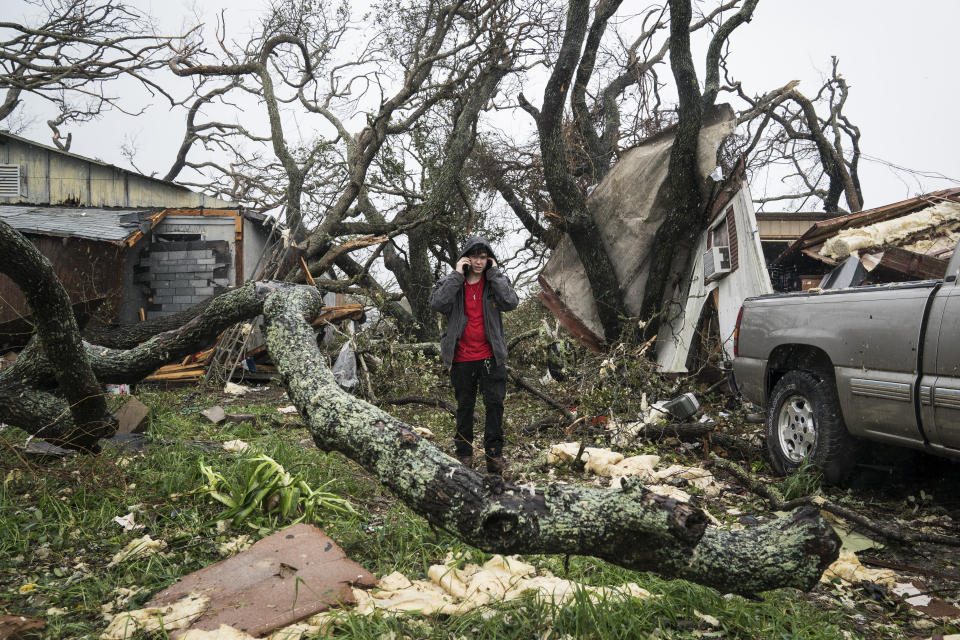 People gather supplies out of destroyed homes to take back to a shelter near City-By-The Sea, Texas.