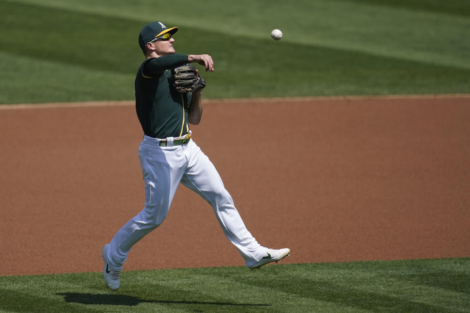 Oakland Athletics third baseman Matt Chapman makes a throwing error on San Diego Padres' Manny Machado's ground ball during the first inning of a baseball game in Oakland, Calif., Saturday, Sept. 5, 2020. (AP Photo/Jeff Chiu)