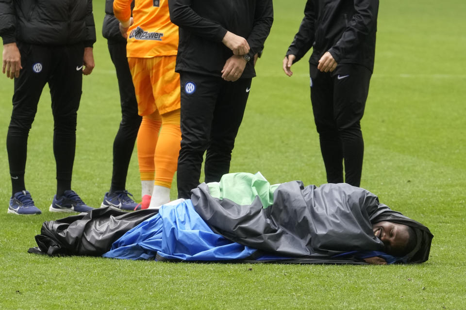 Inter Milan's Marcus Thuram celebrates lying wrapped in a plastic sheet at the end of a Serie A soccer match between Inter Milan and Torino at the San Siro stadium in Milan, Italy, Sunday, April 28, 2024. Inter Milan had already clinched the Italian Serie A league title the week before. (AP Photo/Luca Bruno)