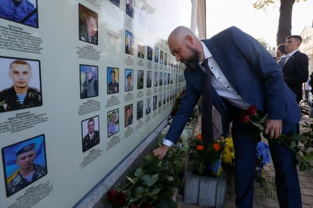Newly elected lawmaker Dmytro Nalotov places flowers on a monument to Ukrainian servicemen, who were killed during a military conflict in the country's eastern regions, on his way to the building of parliament in central Kiev