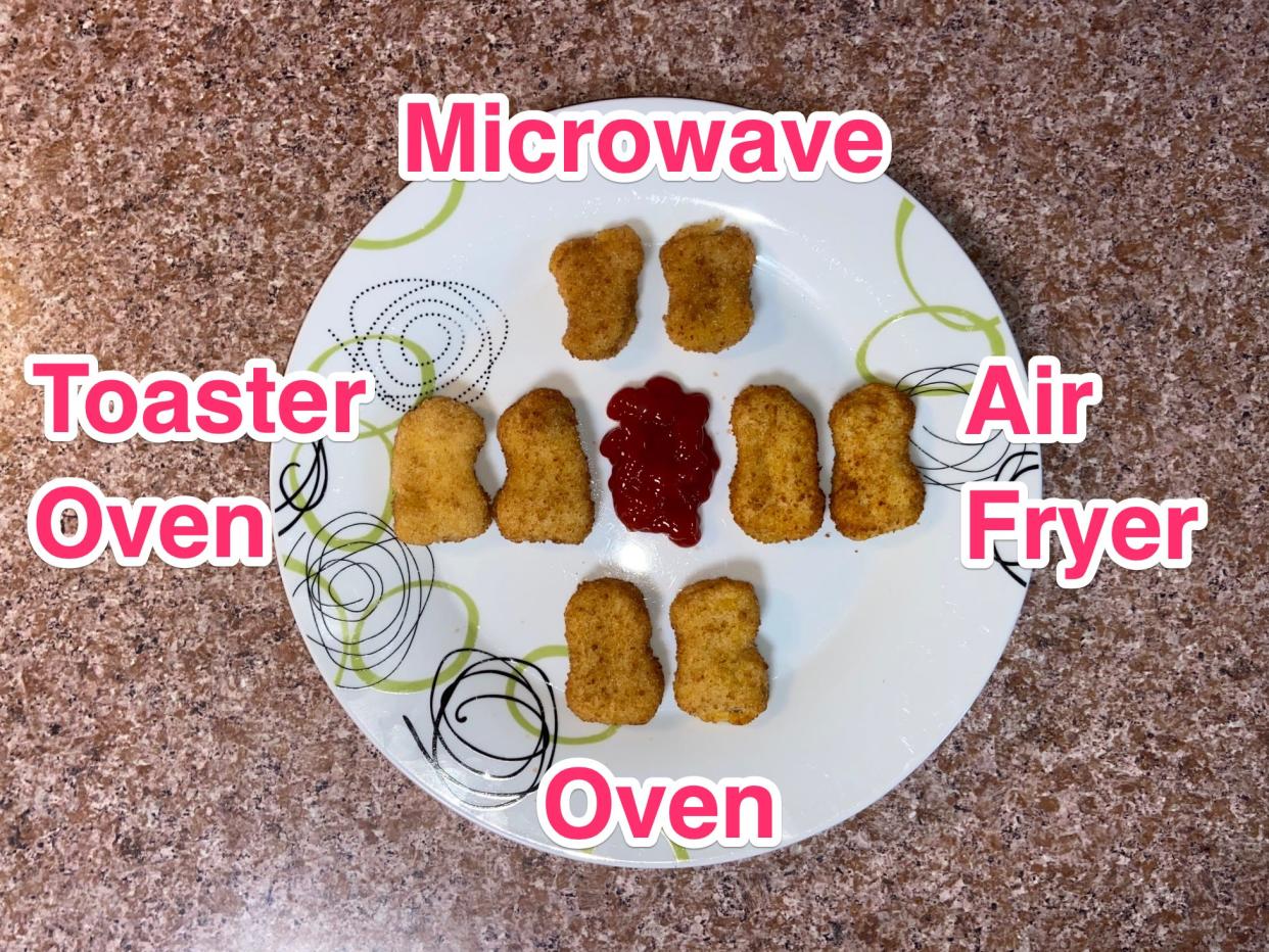 A plate with eight chicken nuggets on it separated by their cooking method with the labeled words "microwave," "toaster oven," "oven," and "air fryer." There is ketchup in the middle of the nuggets.