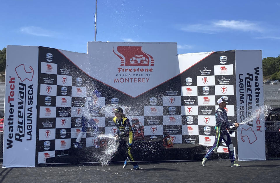 Colton Herta, center, celebrates his IndyCar victory at Laguna Seca with runner-up Alex Palou, left, and Romain Grosjean, right, Sunday, Sept. 19, 2021, in Monterey, Calif. Palou stretched his lead in the championship standings to 35 points headed into next week's season finale. (AP Photo/Jenna Fryer)