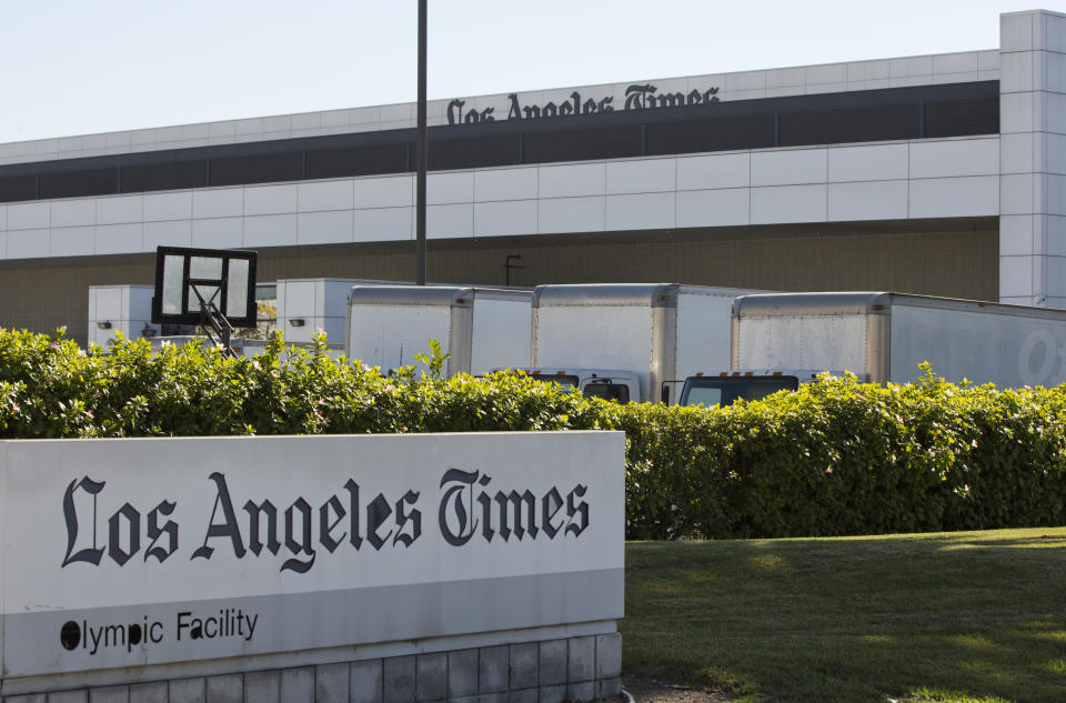 Delivery trucks are parked outside the Los Angeles Times Olympic Facility in Los Angeles, Sunday, Dec. 30, 2018. A computer virus hit the newspaper printing plant in Los Angeles, and at Tribune Publishing newspapers across the country. (AP Photo/Damian Dovarganes)