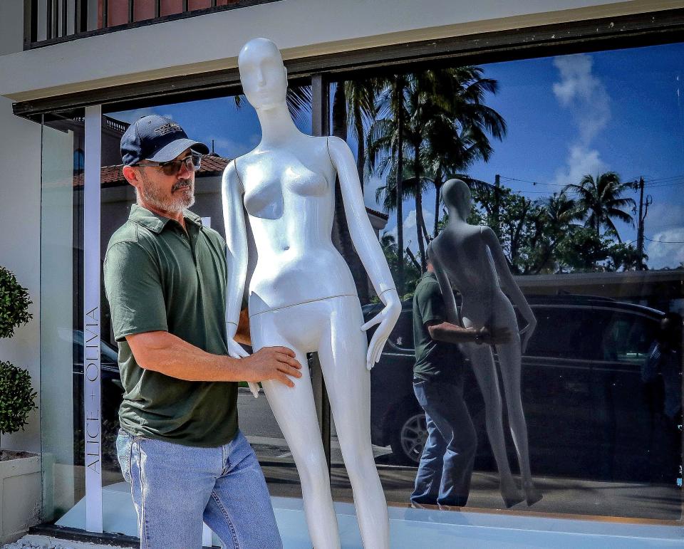 Robert Bernard, who is a body armor vendor for the Town of Palm Beach police department, carries one of several mannequins down Worth Ave. that were donated to him and his wife Cathie Nash by Saks Fifth Avenue on July 1.