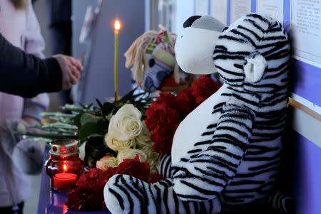 People bring flowers and toys in memory of victims of a recent incident, which involved an Aeroflot Sukhoi Superjet 100 passenger plane during a flight from Moscow to Murmansk, at the airport of Murmansk, Russia May 6, 2019. REUTERS/Stringer