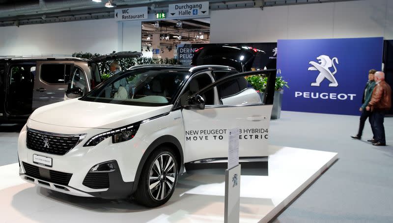 FILE PHOTO: Logo of French car manufacturer Peugeot is seen behind a SUV 3008 Hybrid4 car displayed in Zurich