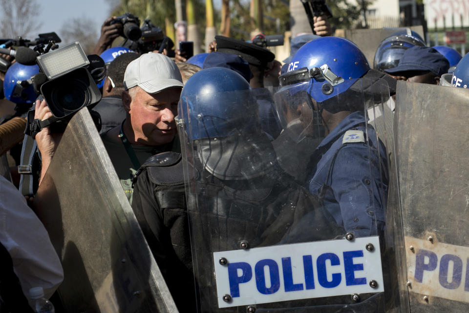 Riot police outside the Bronte hotel, where a press conference by opposition leader Nelson Chamisa was scheduled to take place, in Harare, Zimbabwe, Friday Aug. 3, 2018. Hours after President Emmerson Mnangagwa was declared the winner of a tight election, riot police disrupted a press conference where opposition leader Nelson Chamisa was about to respond to the election results. (AP Photo/Jerome Delay)