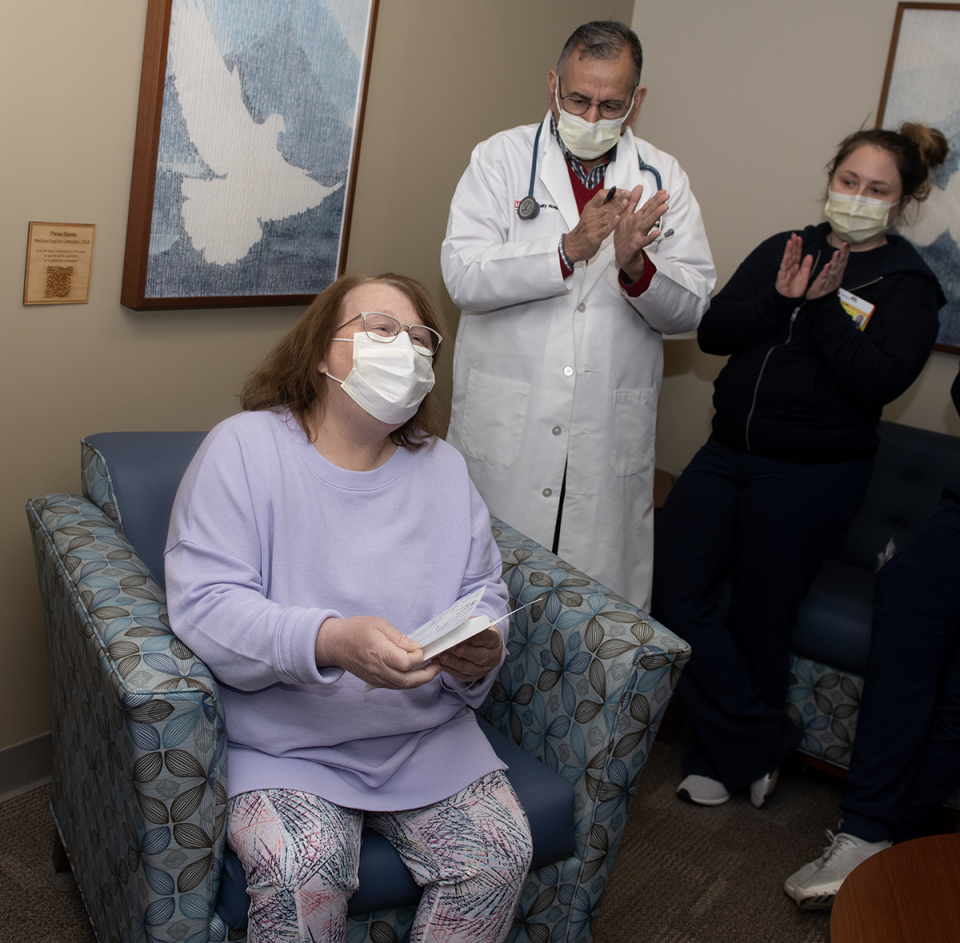 Debra Holloway reacts after opening an envelope with a check in it from the Kent Police Department at UH Portage Medical Center's Seidman Cancer Center on Wednesday.