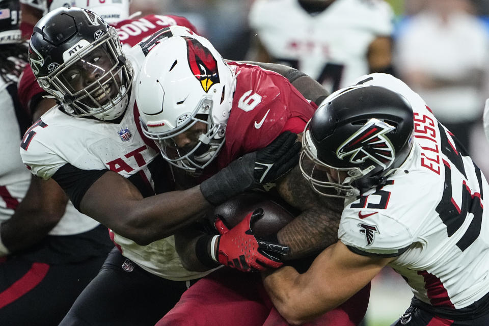 Arizona Cardinals running back James Conner (6) is wrapped up by Atlanta Falcons defensive end Zach Harrison (96) and linebacker Kaden Elliss (55) during the second half of an NFL football game, Sunday, Nov. 12, 2023, in Glendale, Ariz. (AP Photo/Matt York)