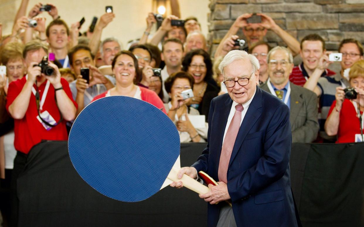 Warren Buffet uses an oversized paddle against Olympian Ariel Hsing during several rounds of ping pong at a Berkshire Hathaway shareholder meeting in Omaha, May 2012