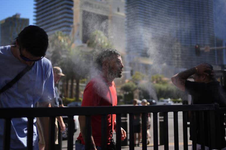 La gente se refresca en los vaporizadores a lo largo del Strip de Las Vegas en medio de una ola de calor persistente que se espera que continúe arrasando gran parte de EE. UU. hasta el fin de semana 