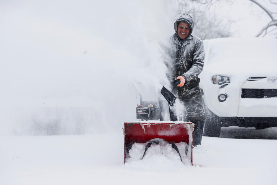 Francisco Erazo uses his snow blower to clear snow on Friday, Dec. 23, 2022 in Grand Rapids, Mich. A blizzard warning is in effect for Kent County and the surrounding region. Winter weather is blanketing the U.S. as a massive storm sent temperatures crashing and created whiteout conditions. (Neil Blake/The Grand Rapids Press via AP)