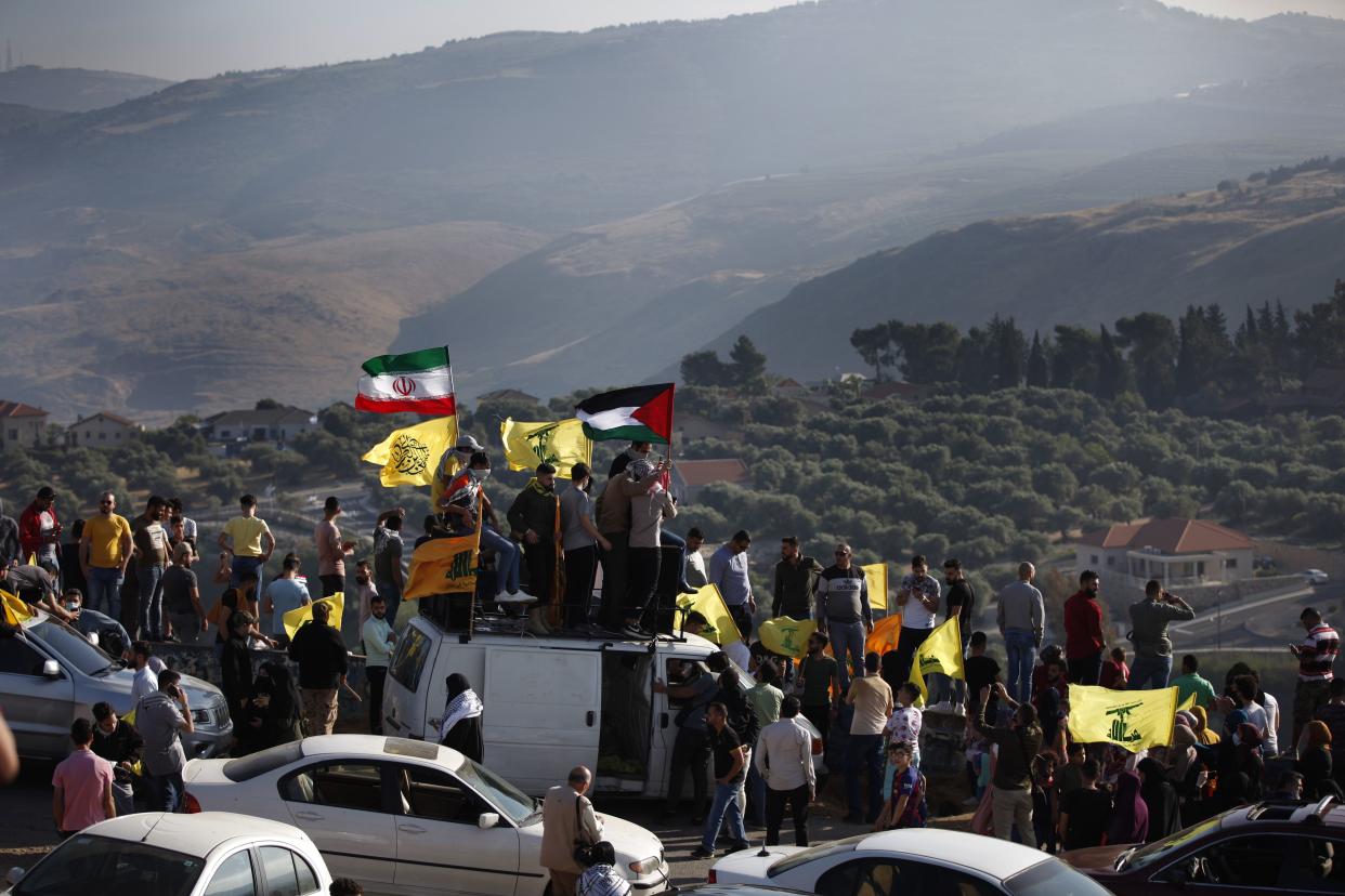 Hezbollah supporters wave their group, Iranian and Palestinian flags, during a protest in solidarity with Palestinians near the southern village of Kafr Kila, Lebanon, on Friday. 