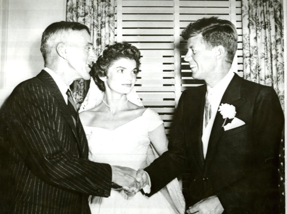 Senator Leverett Saltonstall congratulates Sen. John F. Kennedy at the wedding reception as Kennedy's wife, Jacqueline Bouvier, looks on, Sept. 12, 1953. (Photo by Charles McCormick/The Boston Globe via Getty Images)