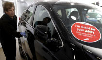 Balbir Singh Gill cleans a car door at the Trident Honda car dealership in Ottershaw, England, Friday, May 29, 2020. Lockdown restrictions are being lifted in England with car sales showrooms allowed to reopen from Monday. The Trident Honda showroom has strict social distancing measures in place with reduced cars on show to allow distancing and rigorous cleaning schedules arranged. (AP Photo/Kirsty Wigglesworth)