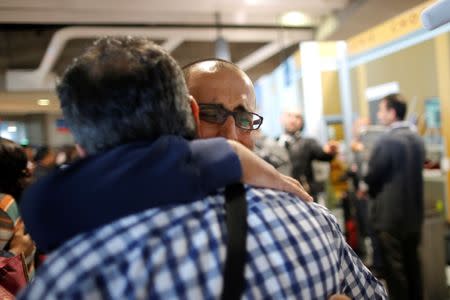 Christian Syrian refugee Sami Aleid (R) hugs his brother Emmanuel Aleid who arrived with fifteen family members from Beirut, at the Charles-de-Gaulle Airport in Roissy, France, October 2, 2015. REUTERS/Stephane Mahe