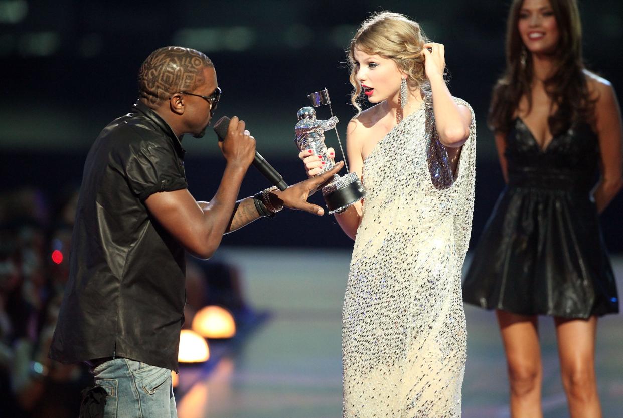 Kanye West (L) jumps onstage after Taylor Swift (C) won the "Best Female Video" award during the 2009 MTV Video Music Awards at Radio City Music Hall on September 13, 2009 in New York City.