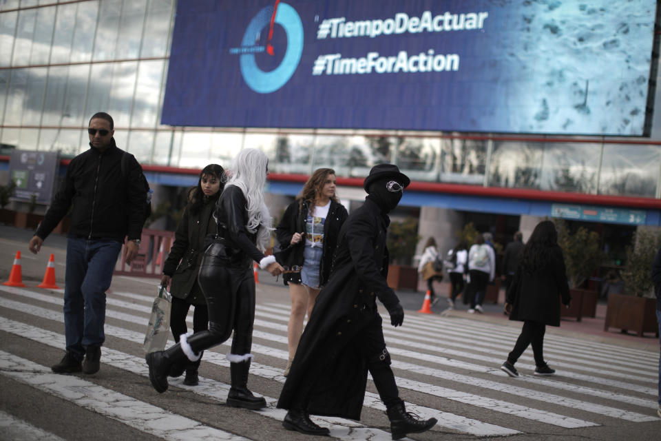 People walk outside of the COP25 climate talks congress in Madrid, Spain, Saturday, Dec. 14, 2019. The United Nations Secretary-General has warned that failure to tackle global warming could result in economic disaster. (AP Photo/Manu Fernandez)