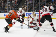 Ottawa Senators' Thomas Chabot, left, hits the puck away from Anaheim Ducks' Jakob Silfverberg, left, as Senators goaltender Anton Forsberg, center, watches during the second period of an NHL hockey game Friday, Nov. 26, 2021, in Anaheim, Calif. (AP Photo/Jae C. Hong)