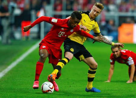 Bayern Munich's Kingsley Coman fights for the ball with Borussia Dortmund's Marco Reus (R) during their German first division Bundesliga soccer match in Munich, Germany, October 4, 2015. REUTERS/Michaela Rehle