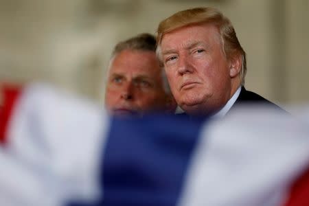 U.S. President Donald Trump, flanked by Virginia Governor Terry McAuliffe, participates in the commissioning ceremony of the aircraft carrier USS Gerald R. Ford at Naval Station Norfolk in Norfolk, Virginia, U.S. July 22, 2017. REUTERS/Jonathan Ernst