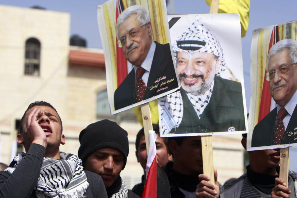 Palestinians shout slogans to support Palestinian President Mahmoud Abbas, calling him "Abo Mazen," his name locally known, ahead of his meeting with U.S. President Barack Obama next week, while holding a rally in the West Bank town of Tubas on Sunday, March 16, 2014. The pictures at center and far right is Abbas and late Palestinian leader Yasser Arafat, center right. (AP Photo/Mohammed Ballas)