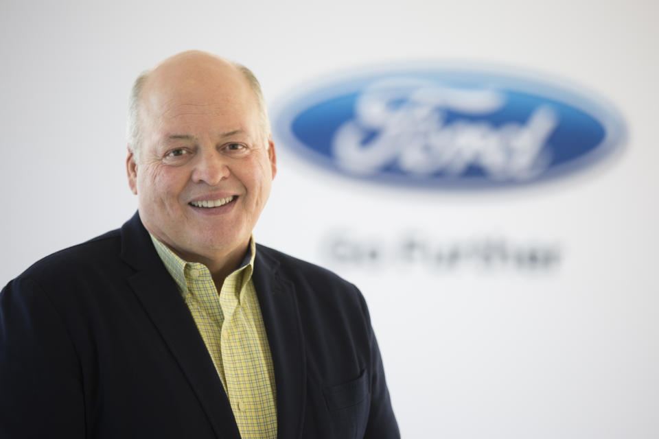 Ford CEO Jim Hackett in front of a white backdrop with a blue Ford logo.