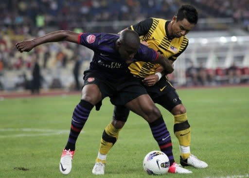 Arsenal's player Benik Afobe (L) fights for the ball with Malaysia's player Aidil Zafuan Razak (R) during their soccer friendly match in Bukit Jalil Stadium, some 20 kilometres south of Kuala Lumpur. Arsenal manager Arsene Wenger denied he was close to signing Spain's Santi Cazorla as the English football giants kicked off an Asian tour Tuesday with a narrow 2-1 victory over hosts Malaysia