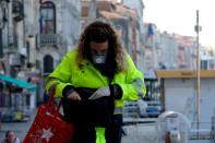 A mailwoman wearing a protective mask is seen in Venice on the second day of an unprecedented lockdown across of all Italy imposed to slow the outbreak of coronavirus, in Venice