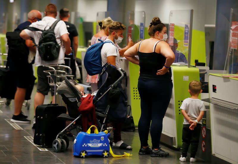 British tourists returning to UK, check in their luggage, as Britain imposed a two-week quarantine on all travellers arriving from Spain