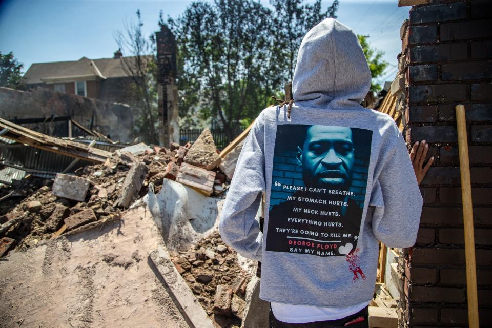 Brandy Moore wares a George Floyd hoodie as she stands over the rubble of her clothing store Levels Sunday, May 31, 2020. Her Minneapolis business was looted and burned during protests over the death of George Floyd. 