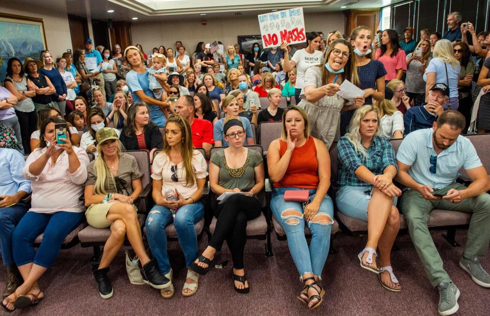 Angry residents react when the Utah County Commission meeting was adjourned before it even started, Wednesday, July 15, 2020, in Provo, Utah. The group protesting against face masks being required in schools removed the social distancing tape on the chairs and filled the Utah County Commission room to over flowing, prompting Commissioner Tanner Ainge to call for a vote to adjourn the meeting.