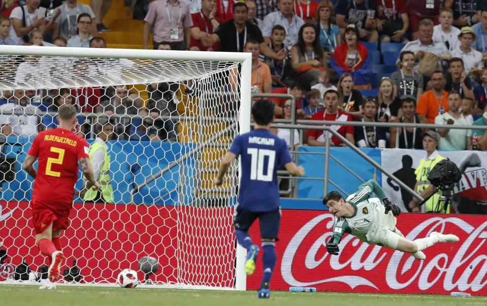 Japan’s Genki Haraguchi scores the opening goal as the Belgium goalkeeper Thibaut Courto tries to stop the ball during the round of 16 match between Belgium and Japan at the 2018 soccer World Cup in the Rostov Arena, in Rostov-on-Don, Russia, Monday, July 2, 2018. (AP Photo/Rebecca Blackwell)