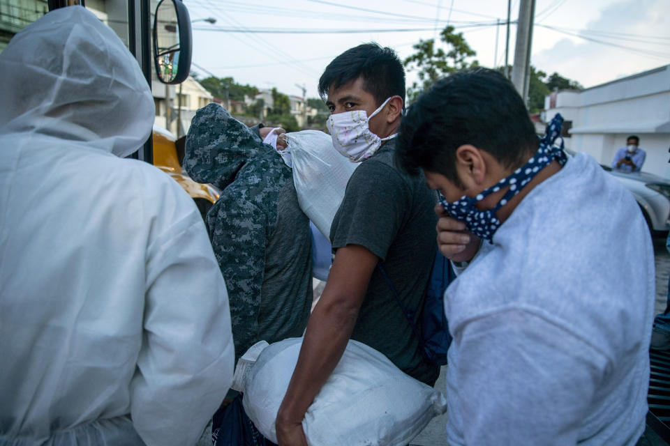 Guatemalans deported from the U.S., wearing a mask as a precaution against the spread of the new coronavirus, line up to board a bus after arriving at La Aurora airport in Guatemala City, Tuesday, June 9, 2020. The United States resumed deportation flights to Guatemala, nearly a month after the Central American country refused to accept them. (AP Photo/Moises Castillo)