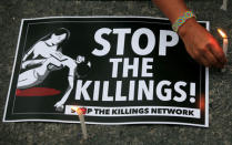 A protester lights candles next to a placard, seeking justice for 17-year-old high school student Kian delos Santos, who was killed in a recent police raid in an escalation of President Rodrigo Duterte's war on drugs, during a protest in front of the Philippine National Police (PNP) headquarters in Quezon city, Metro Manila, Philippines August 23, 2017. REUTERS/Romeo Ranoco