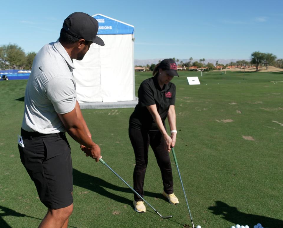 PGA star Tony Finau gives some pointers to La Quinta restaurant owner Katherine Gonzalez on the driving range at PGA West on Tuesday.